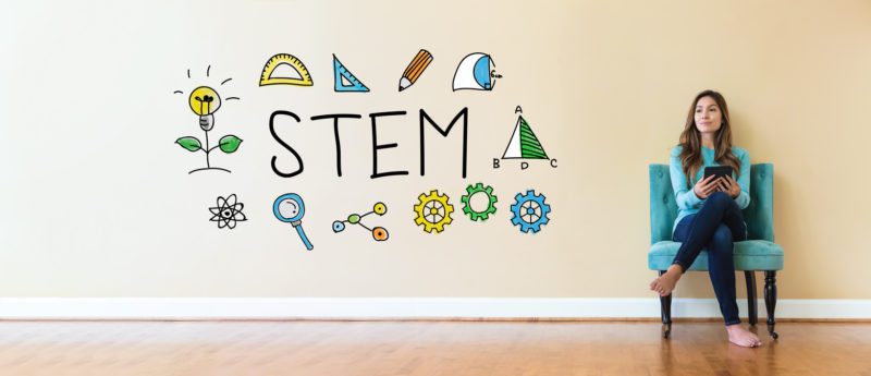 STEM text with young woman holding a tablet computer in a chair