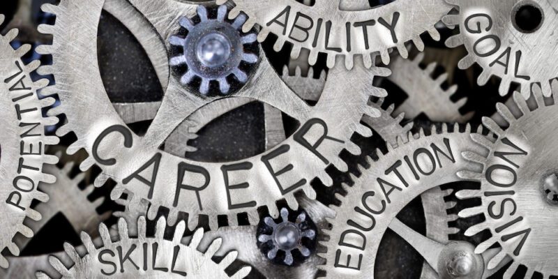 Macro photo of tooth wheel mechanism with CAREER, EDUCATION, ABILITY, VISION, SKILL, GOAL and POTENTIAL words imprinted on metal surface