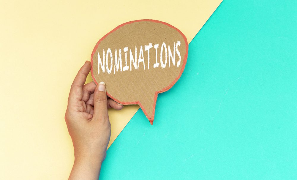 closeup hand holding nominations speech bubbl